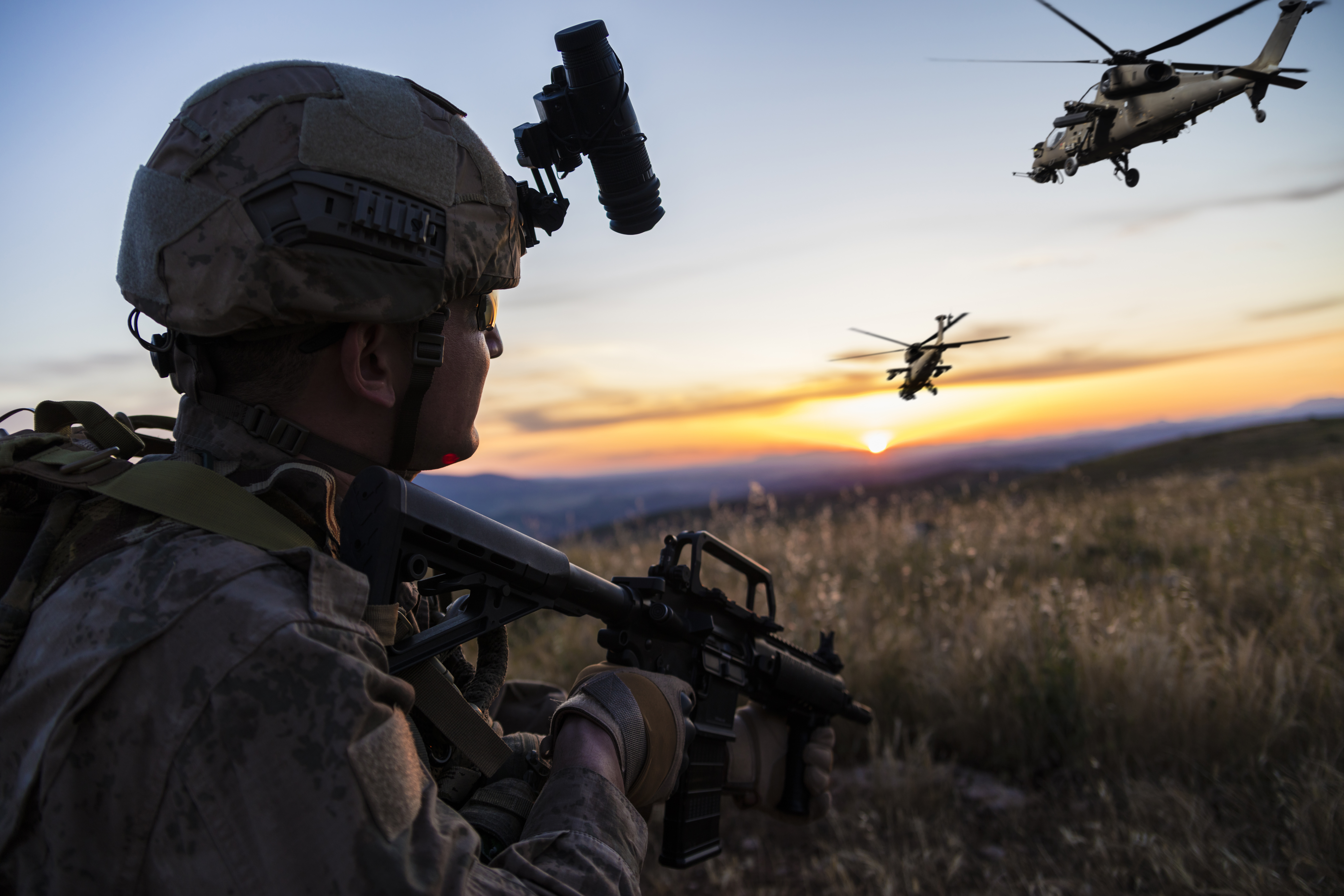 soldier with helicopters in background