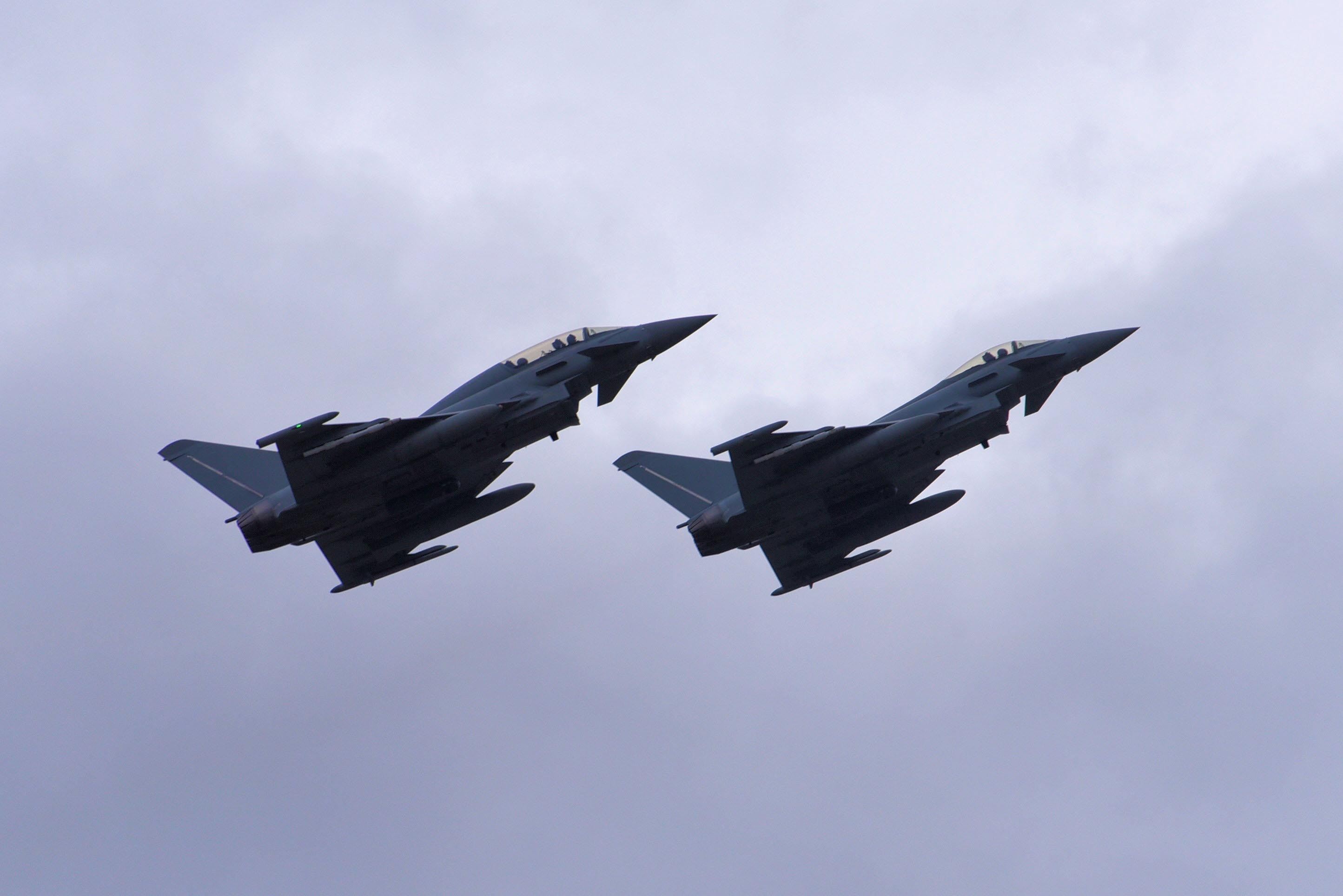 two jets flying parallel in a cloudy sky